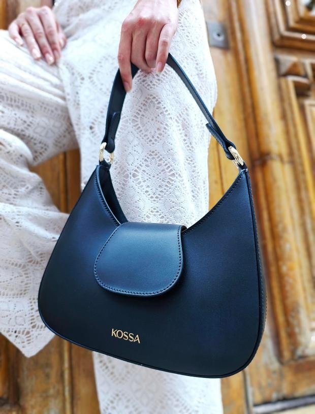 Sac Nubia Noir porté avec un pantalon blanc